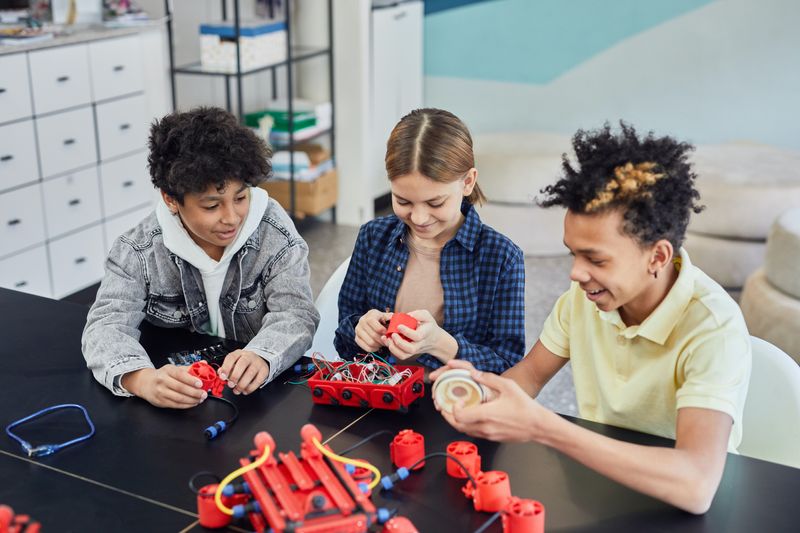 Three children building a robot together
