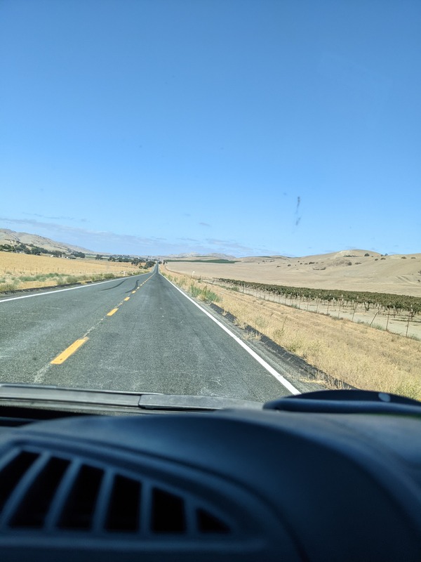Photo through the van windshield of the open road stretching into the distance 