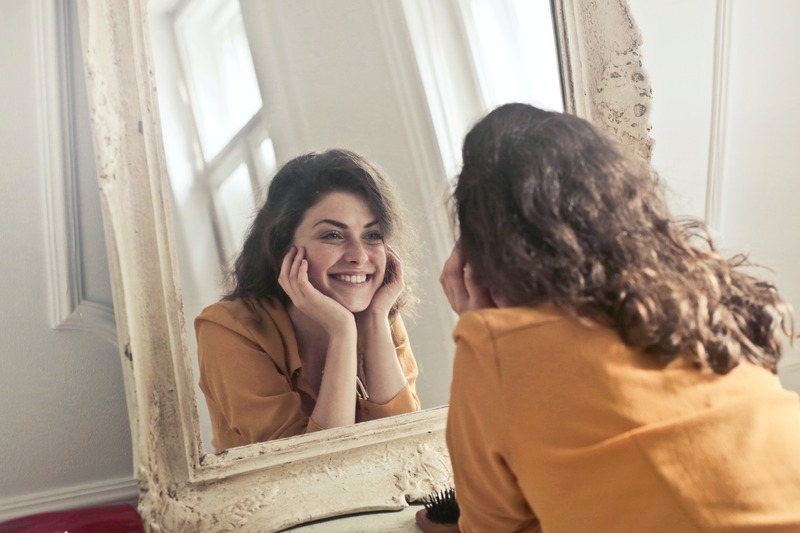 Person looking in a mirror and smiling